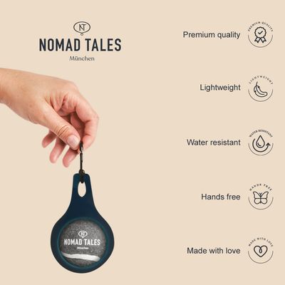 Nomad Tales München. Jakość premium, lekki, wodoodporny, do noszenia bez użycia rąk, wykonany z miłością. Ręka trzyma produkt z karabińczykiem.
