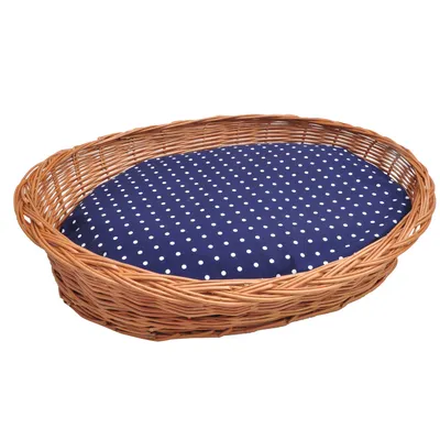 Cesto intrecciato ovale con cuscino blu scuro a pois bianchi. Adatto come letto o area di riposo.