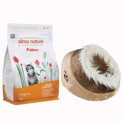 Almo Nature Kitten 2–12 months 2 kg, sacco di crocchette per gattini, accanto a cuccia beige in tessuto con gatto all'interno e simbolo percentuale arancione per offerta.