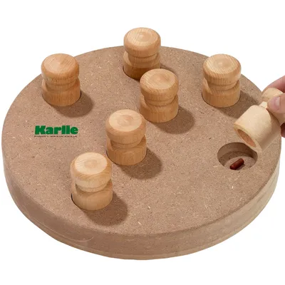 Jeu d’intelligence en bois rond avec 7 pions amovibles, marque Karli visible, une main soulève un pion révélant une friandise dans un trou. Jeu d’intelligence en bois rond avec 7 pions amovibles, marque Karli visible, une main soulève un pion révélant une friandise dans un trou.