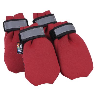 Roter Pfotenschutz mit schwarzen Zickzack-Gummistreifen und Klettverschluss, seitlich ein Etikett mit blauem Kreuz.