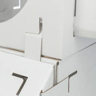 Detailní záběr na bílý kartonový materiál se zásuvným systémem, vhodný pro stavbu nebo montáž.