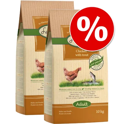 Two 10 kg bags labelled 'Chicken with trout', 'Adult', cold-pressed, visible chicken and fish images, red percentage discount symbol top right. Some text in English, German, French. Two 10 kg bags labelled 'Chicken with trout', 'Adult', cold-pressed, visible chicken and fish images, red percentage discount symbol top right. Some text in English, German, French.