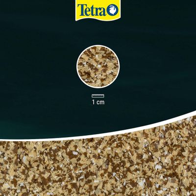 Tetra. Vista dettagliata del mangime in fiocchi con scala di misura, mostra la taglia dei fiocchi: 1 cm.