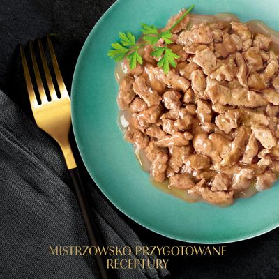 Talerz z kawałkami mięsa w sosie, udekorowany pietruszką. Tekst: Mistrzowsko przygotowane receptury.