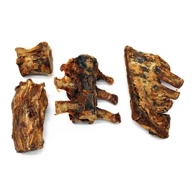 Vier Stücke getrocknete Knochen und Rippen, geeignet als natürlicher Kausnack. Sichtbare braune und knorpelige Textur.