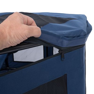 Mano apre la cerniera di un trasportino blu con finestre a rete.