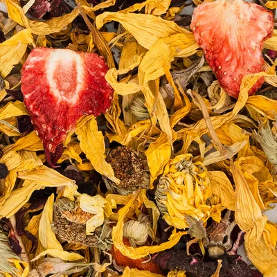 Mélange de pétales de fleurs séchées jaunes et brunes avec morceaux visibles de fraise séchée, ingrédients entiers reconnaissables sans emballage ni marque apparente.