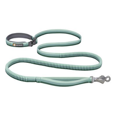 Trela verde claro Ruffwear com pega almofadada, fecho metálico e secção elástica visível. Marca Ruffwear identificada na pega.