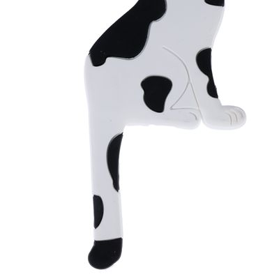 Black and white cat figurine, partially visible, with spotted pattern.