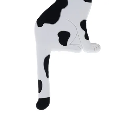 Black and white cat figurine, partially visible, with spotted pattern.