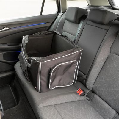 Zwarte transporttas met reflecterende strepen en zijvak, geplaatst op de achterbank van een auto.