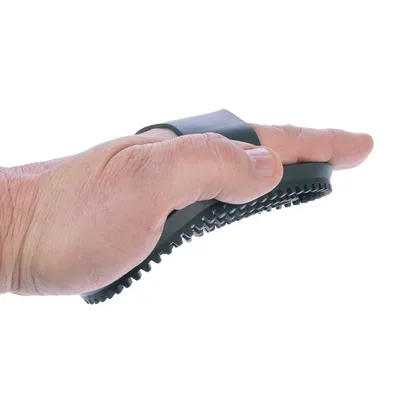 Mano che tiene una spazzola in gomma nera con dentini, adatta per la cura del pelo.