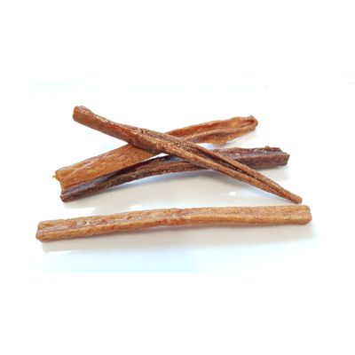 Diversi snack da masticare essiccati a forma di bastoncino, colore marrone, su sfondo bianco.