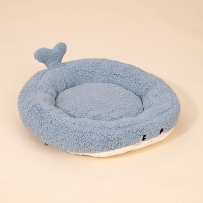 Rundes, blaues Bett aus Plüsch mit herzförmiger Schwanz-Applikation und aufgesticktem Gesicht an der Vorderseite.