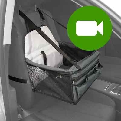 Prezentacja transportera dla zwierząt montowanego na fotelu samochodowym, czarne siateczkowe boki, kieszenie z przodu, pasy mocujące. Ikona wideo w zielonym kółku.