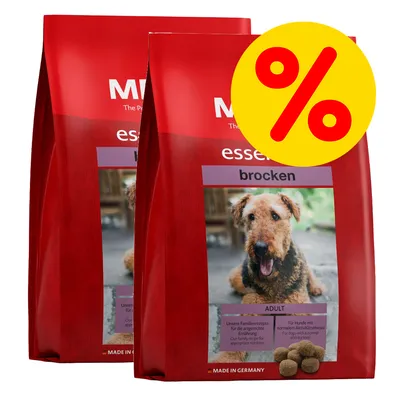 Kaksi punaista koiranruokapussia, joissa tekstiä 'essential brocken', kuvassa ruskea koira. Keltainen alennusmerkki (%). MADE IN GERMANY näkyvissä pakkauksessa.