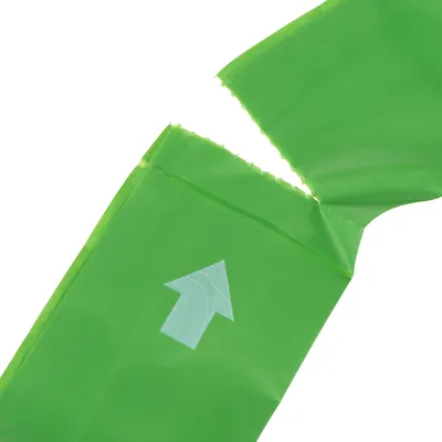 Sachet vert en plastique déchiré avec une flèche blanche imprimée indiquant le sens d’ouverture visible sur l’emballage.