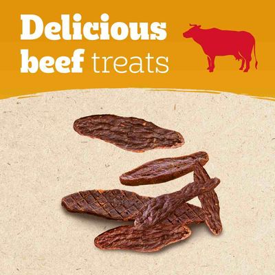 Delicious beef treats – tekst w języku angielskim, ilustracja czerwonej krowy, kilka suszonych przysmaków wołowych na jasnym tle.