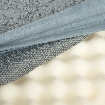 Close-up dos materiais: tecido cinzento macio, tecido têxtil texturizado e espuma ondulada. Representação das camadas de um produto.