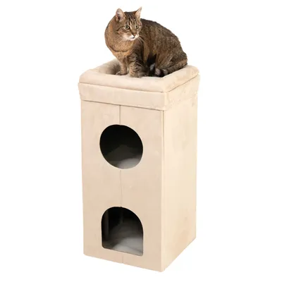 Beige Katzenmöbel mit zwei Höhlen und gepolsterter Liegefläche. Katze sitzt oben auf der Liegefläche.