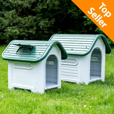 Due cucce per cani in plastica bianca con tetto verde, finestre di ventilazione laterali e scritta Top Seller in alto a destra su sfondo arancione.