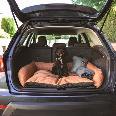 Коричневая лежанка для домашних животных со складным ковриком и темно-серой зоной для лежания. Видимая этикетка на задней стороне.