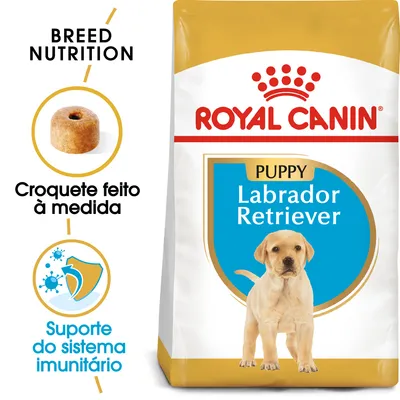 Saco de ração Royal Canin Puppy Labrador Retriever. Texto visível: 'Croquete feito à medida', 'Suporte do sistema imunitário', 'Breed Nutrition'. Imagem de croquete e escudo.