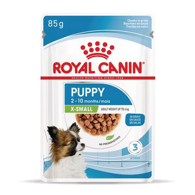 Royal Canin Puppy X-Small 2–10 months, 85 g. Aikuispaino enintään 4 kg. Pala kastikkeessa. Ei säilöntäaineita. Kuvassa pieni koira ja annosruoka.