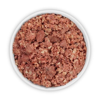 Nourriture humide pour animaux dans une gamelle blanche, mélange de morceaux et pâtée à texture grossière, sans marque visible ni texte.