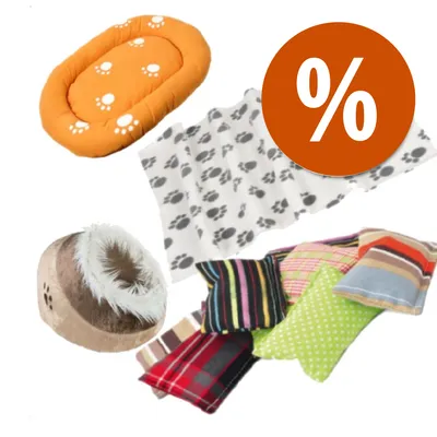 Cuscino arancione con impronte, coperta bianca a impronte nere, cuccia beige pelosa e cuscini colorati assortiti; simbolo percentuale su sfondo arancione per offerta.
