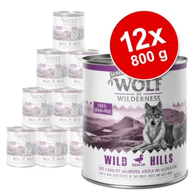 Pack de 12 latas Wolf of Wilderness Senior Wild Hills, 800 g cada una. Texto visible: 100% grain-free, duck & veal with fruits of the forest, roots and wild herbs.