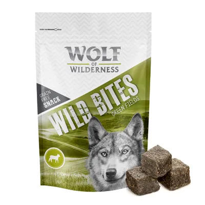 Wolf of Wilderness Wild Bites Green Fields, graanvrije snack. Afbeelding van verpakking met wolvenkop en drie bruine blokjes hondensnack zichtbaar naast de zak.