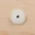 Detalle de un tope redondo de plástico blanco fijado con tornillo metálico sobre superficie de madera clara.