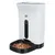 Trixie automatic pet feeder in white with black food tray, filled with dry kibble. Trixie brand name visible on front.