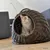 Cat cave made of woven rattan with an orange and white cat inside. Round opening, suitable as a retreat for cats.
