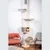Cat tree with multiple levels, including a cave, hammock and resting areas. An orange cat is sitting in the cave.