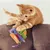 Red cat playing with a colourful burrito-shaped cat toy labelled 'Purrito' and 'Crunchy'.