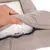 Main ouvrant la housse zippée d’un coussin pour animal, montrant le rembourrage intérieur en tissu blanc sous la surface extérieure beige.