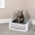 Сива котка седи в сива покрита котешка тоалетна PetSafe върху килим.