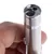 Close-up of a silver laser pointer with metal casing, held by a hand. The lens and a switch on the casing are visible.
