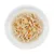 Primo piano di carne di pollo tritata con pezzi di carota e patata in brodo, servita su un piatto bianco.