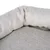 Primer plano de tela beige texturizada con diseño acolchado, posiblemente parte de una cama o cojín para mascotas.