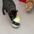 Two cats play with a green interactive bird-shaped toy that dispenses treats.
