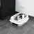 Caja de arena blanca para gatos con entrada y arena, gato sentado dentro. Adecuada para interiores con suelo de baldosas.