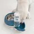 Hund trinkt aus einer blauen Wasserschale mit integriertem Wasserbehälter neben einer Edelstahlnapf-Schale.