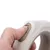 Primo piano di una mano che aziona un interruttore scorrevole beige-grigio su un'impugnatura ergonomica.