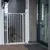 Barrière de sécurité blanche en métal installée à l’extérieur devant une porte, chien visible derrière la barrière.