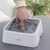 Eyenimal Trinkbrunnen mit Wasserbewegung, demonstriert durch Finger im Wasser.