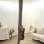 Griffoir colonne verticale en tissu gris, fixé du sol au plafond, avec un chat accroché dessus dans un salon moderne.